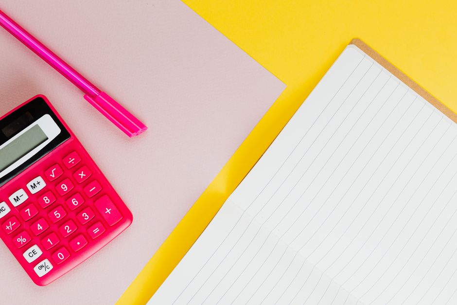 Carnet et calculatrice posés sur un bureau
