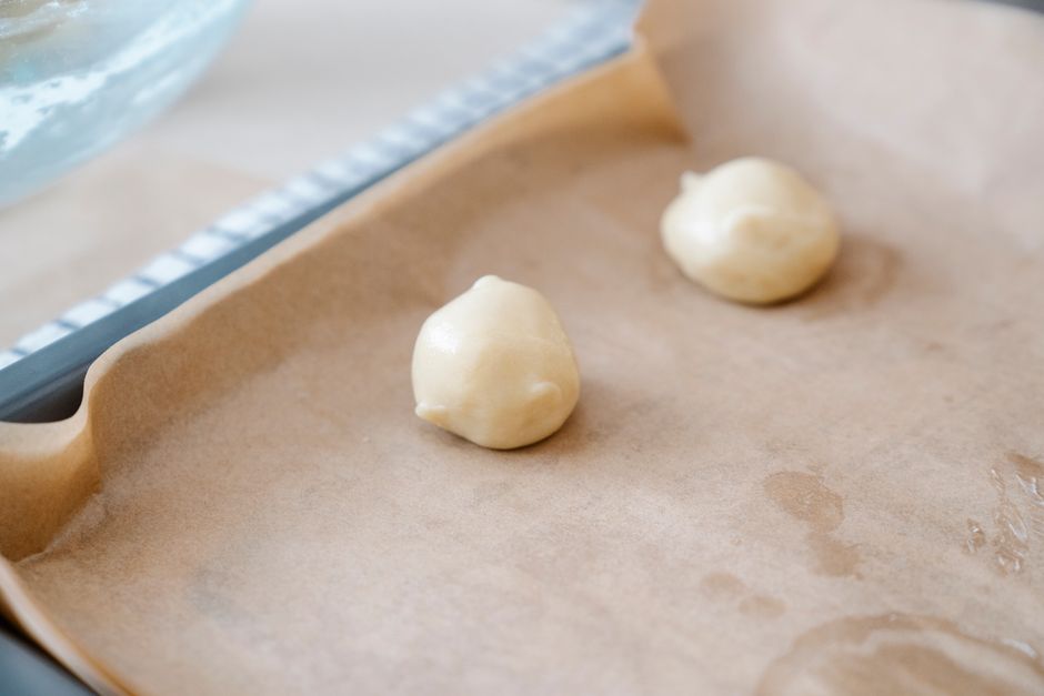 Deux boules de pâte à cookie sur une plaque recouverte de papier cuisson