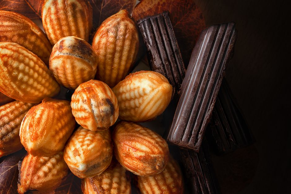 Madeleines et financiers posés sur une planche en bois