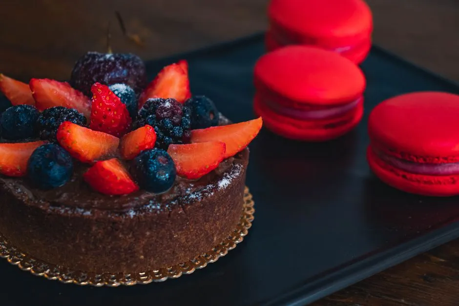Gâteau d'anniversaire au chocolat décoré de macarons et fruits rouges