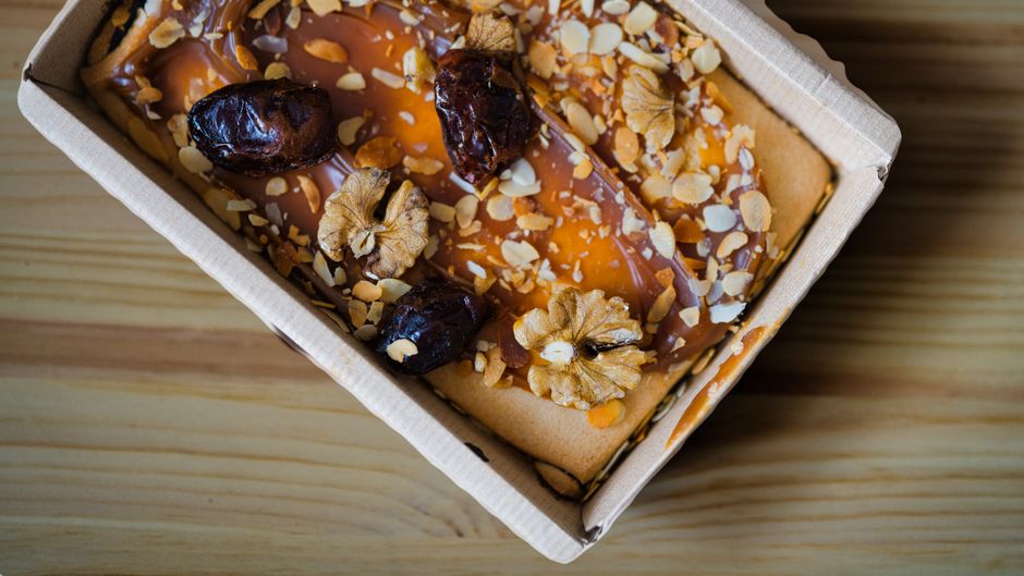 Gâteau aux dattes et fruits secs dans une boîte en carton, vu de dessus