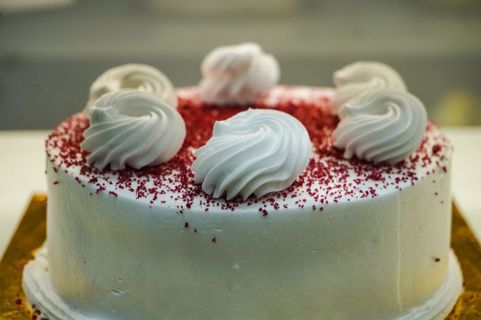Gâteau blanc décoré de meringues et d'éclats de red velvet