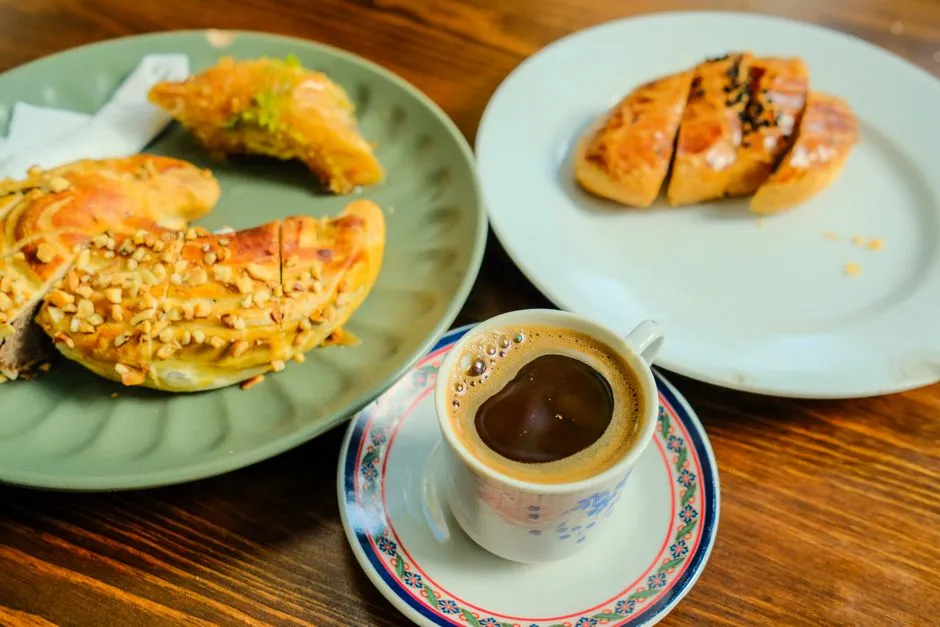 Pâtisseries aux amandes et café servis sur une table en bois
