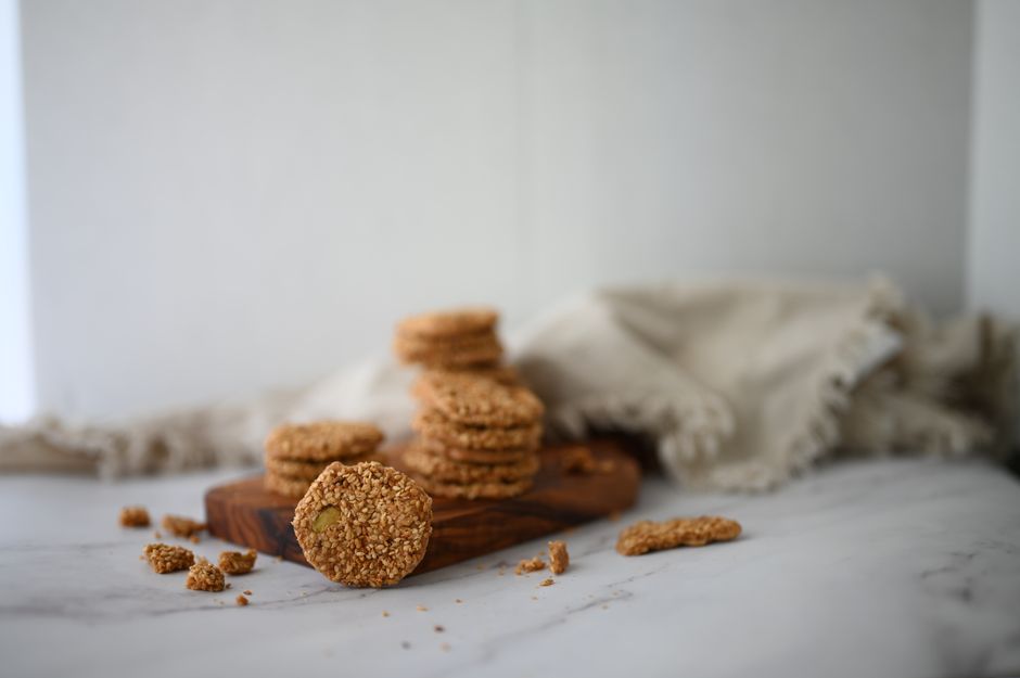 Biscuits fins au sésame empilés sur une planche en bois