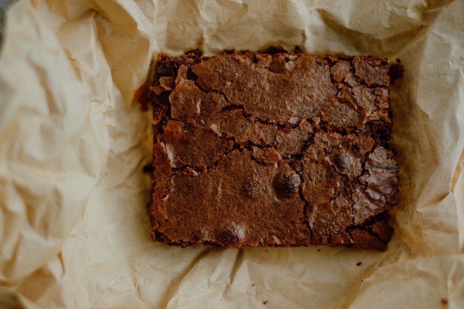 Brownie entier posé sur du papier cuisson froissé, vue de dessus