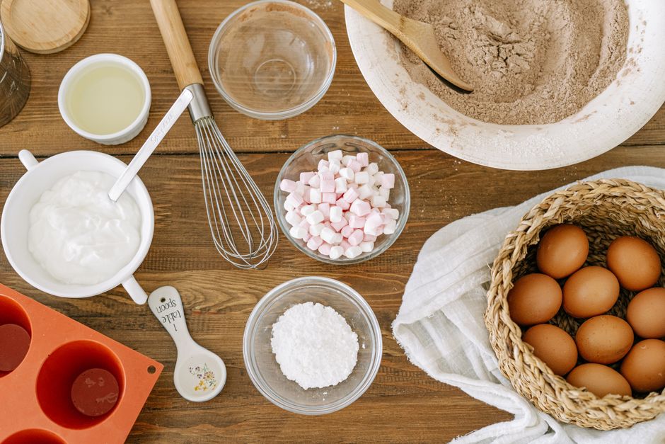 Plan de travail de pâtisserie avec fouet, ingrédients et moule en silicone