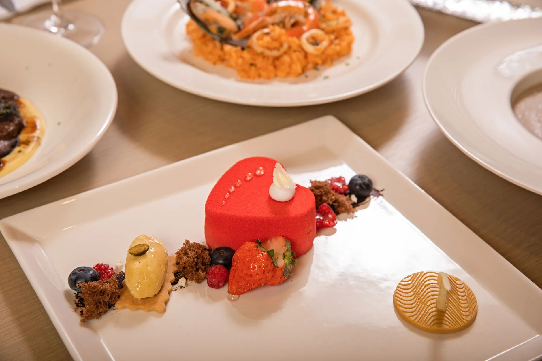 Entremets rouge à l'effet velours servi à l'assiette avec une fraise