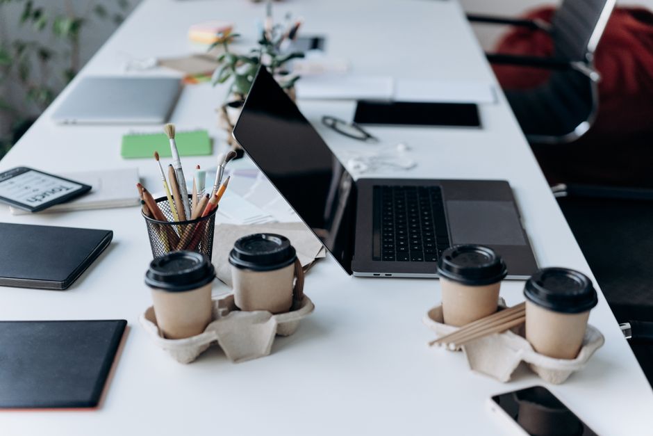 Ordinateur portable ouvert sur un bureau avec carnet et café