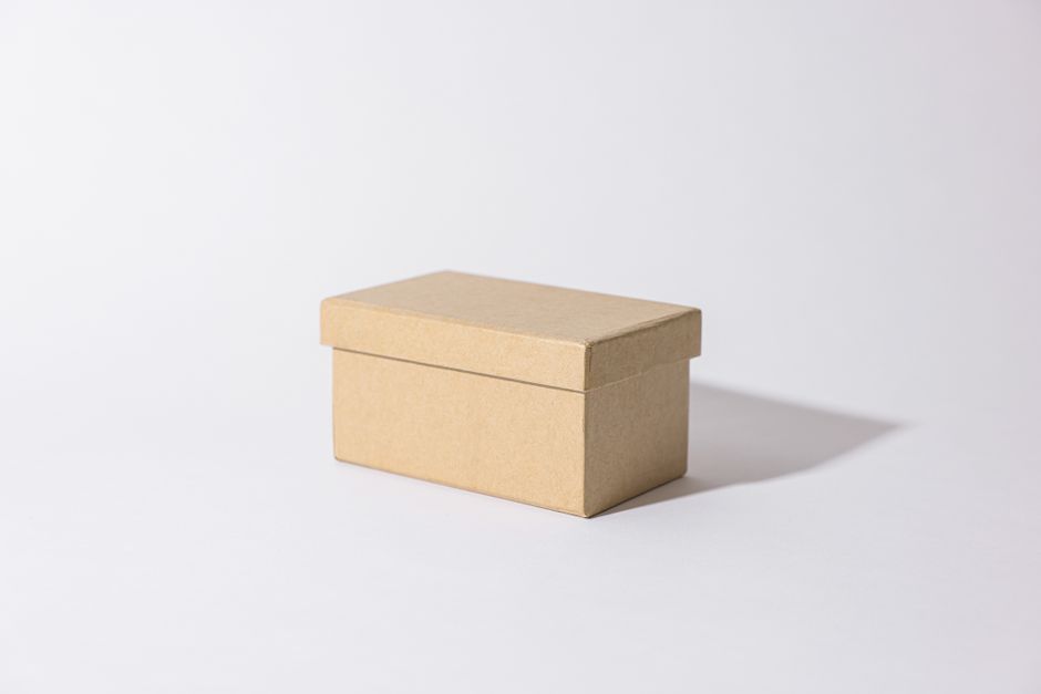 Boîte à pâtisserie en carton kraft, fermée, posée sur une surface claire
