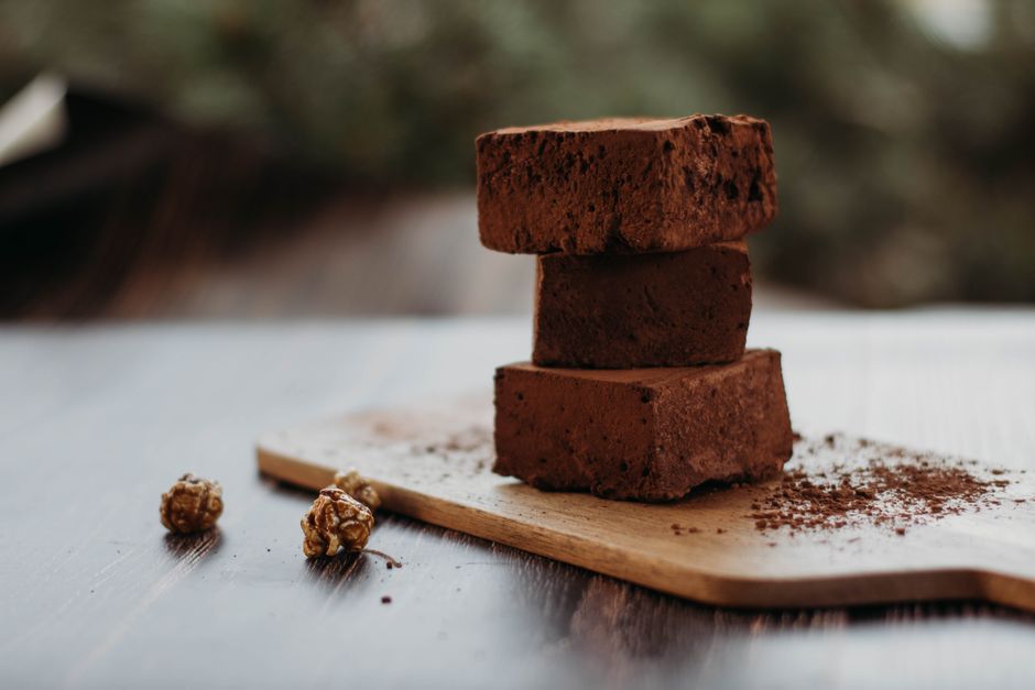 Brownies empilés sur une planche en bois, fond sombre