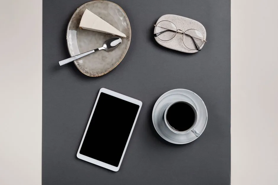 Téléphone posé sur une table à côté d'un cupcake, vu de dessus